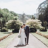 bride and groom hug while on a walk in the park