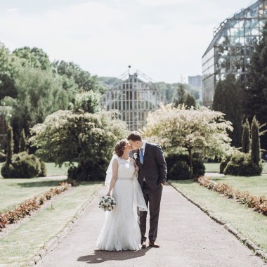 bride and groom hug while on a walk in the park