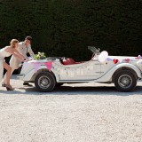 Newlyweds pushing broken down vintage car
