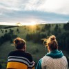 Young couple drinking coffee or tea while standing on their balc