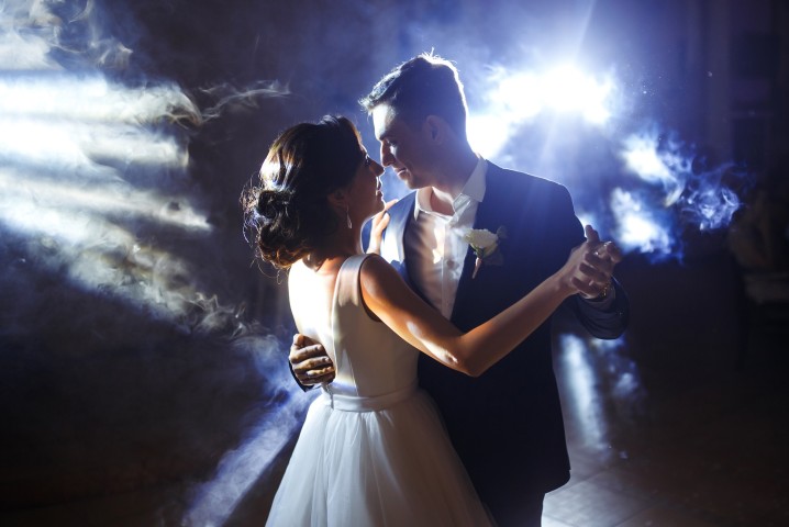 Braut und Bräutigam tanzen ihren Hochzeitstanz im stimmungsvollen Licht mit Nebeleffekt.