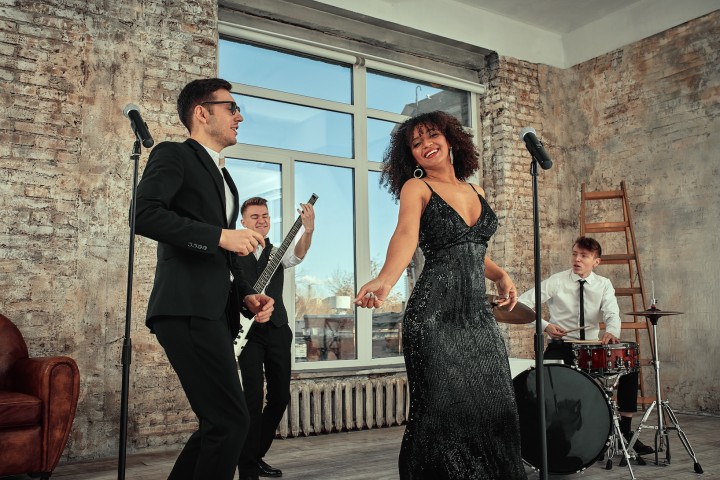 Eine Freundesgruppe performt gemeinsam einen Song für das Hochzeitspaar.