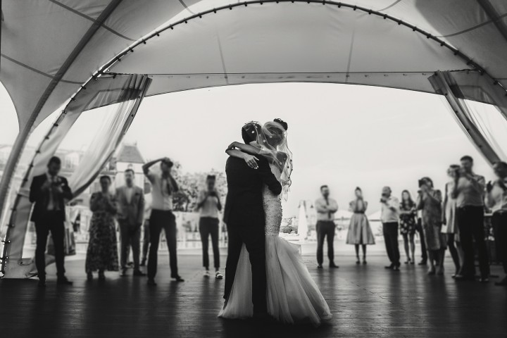 Schwarz weiß Bild von Brautpaar am tanzen auf eigener Hochzeit, Gäste im Hintergrund